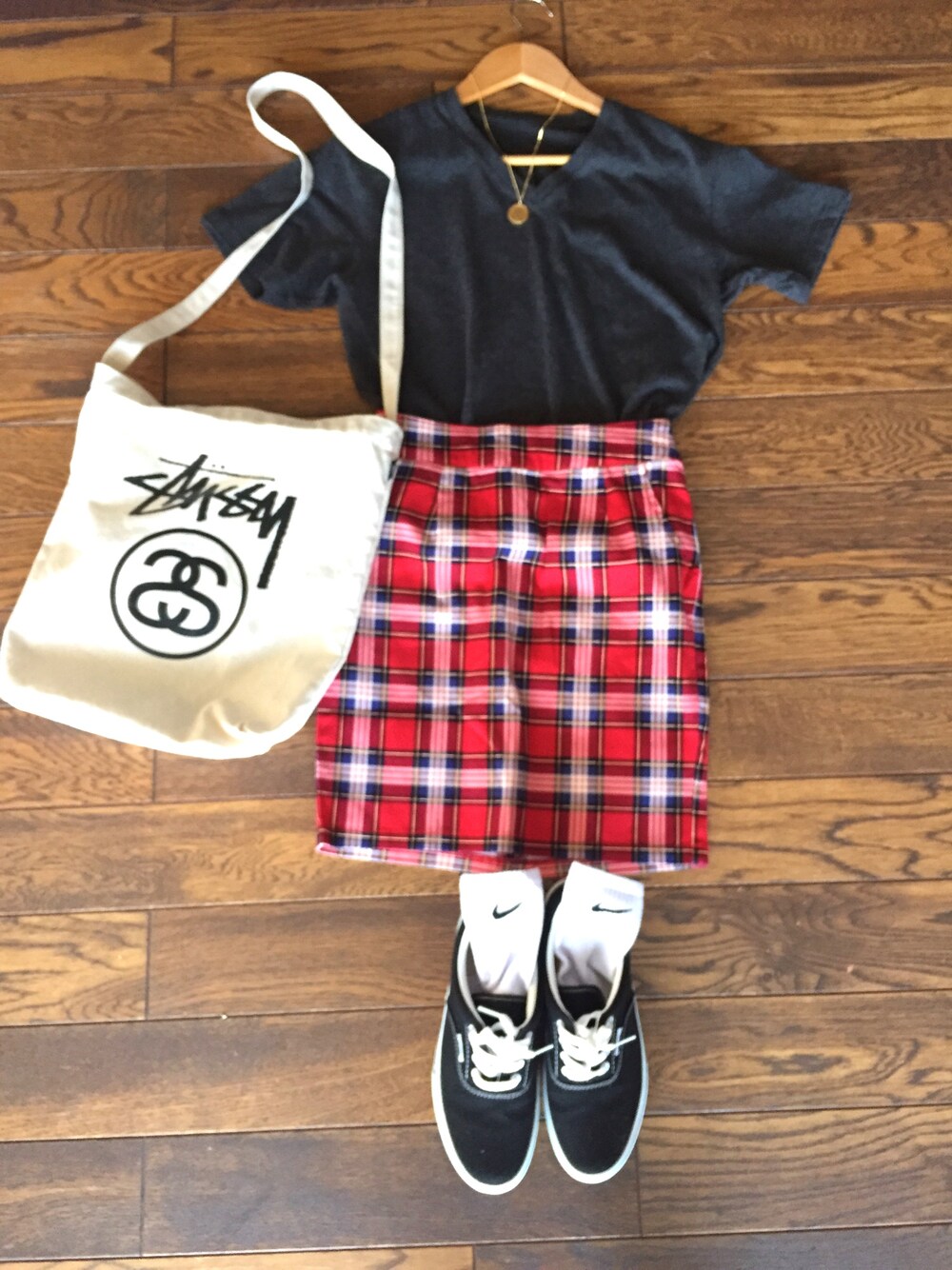ブラック系のスニーカー、レッド系のスカート、ホワイト系のTシャツ/カットソーを着用したレディースの夏コーディネートの1枚目の写真