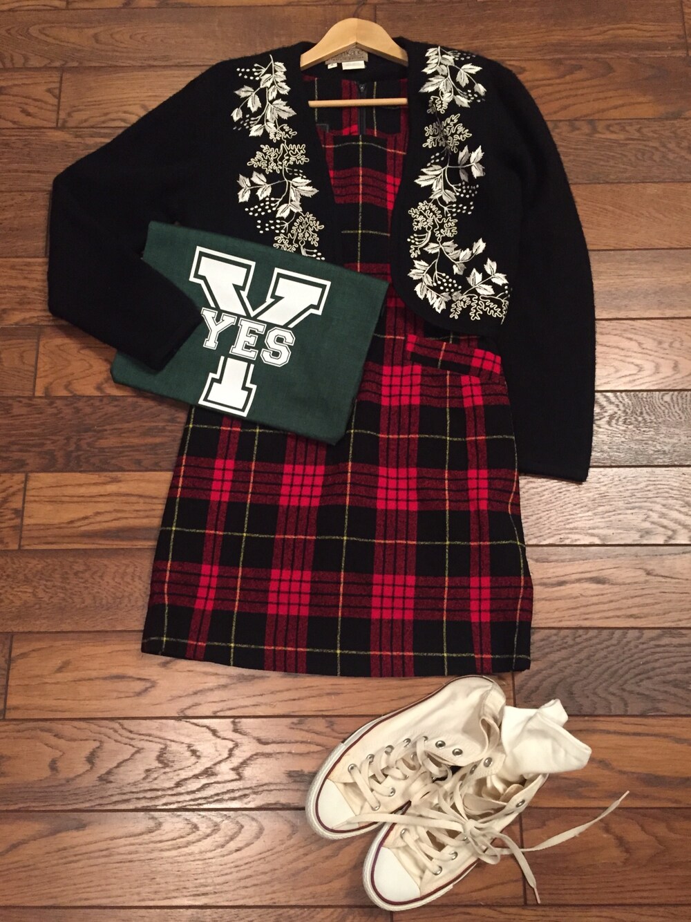 ベージュ系のスニーカー、レッド系のワンピース、グリーン系のクラッチバッグを着用したレディースの秋コーディネートの1枚目の写真