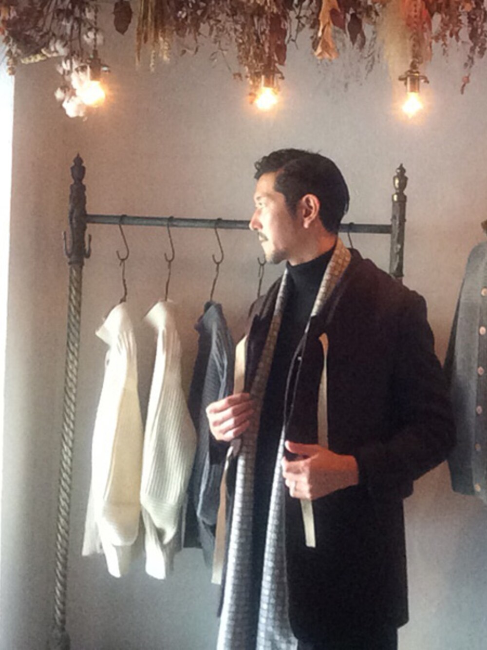 ブラック系のニット/セーター、グレー系のマフラーを着用したメンズの秋コーディネートの1枚目の写真