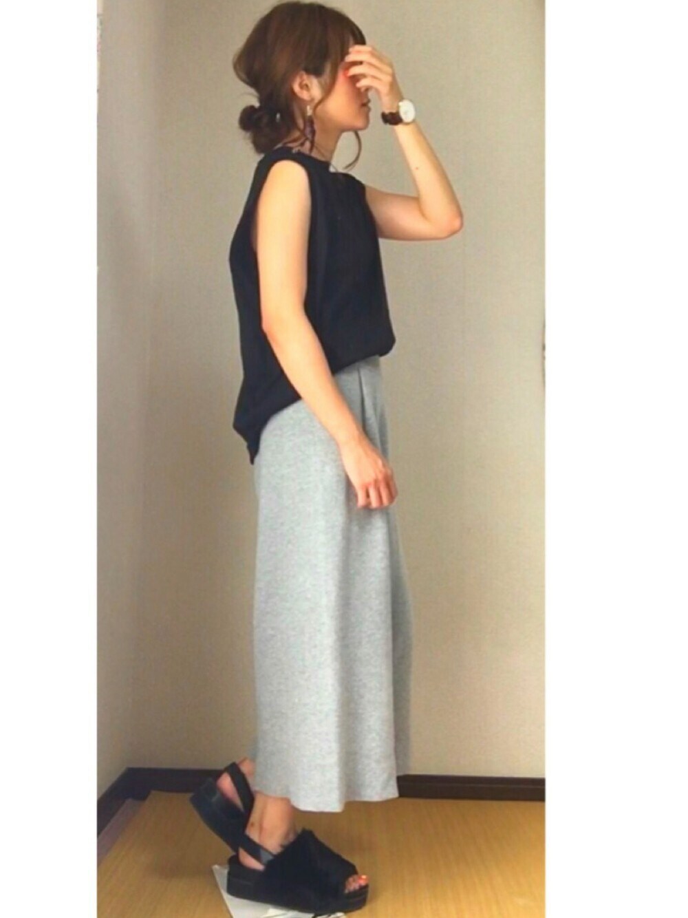 グレー系のパンツ、ホワイト系のトップス、ブラック系のシューズを着用したレディースの夏コーディネートの1枚目の写真