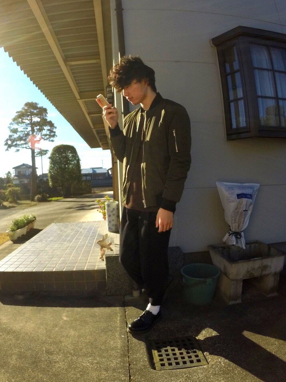 グリーン系のジャケット/アウター、ブラウン系のTシャツ/カットソー、ブラック系のその他パンツを着用したメンズの冬コーディネートの1枚目の写真