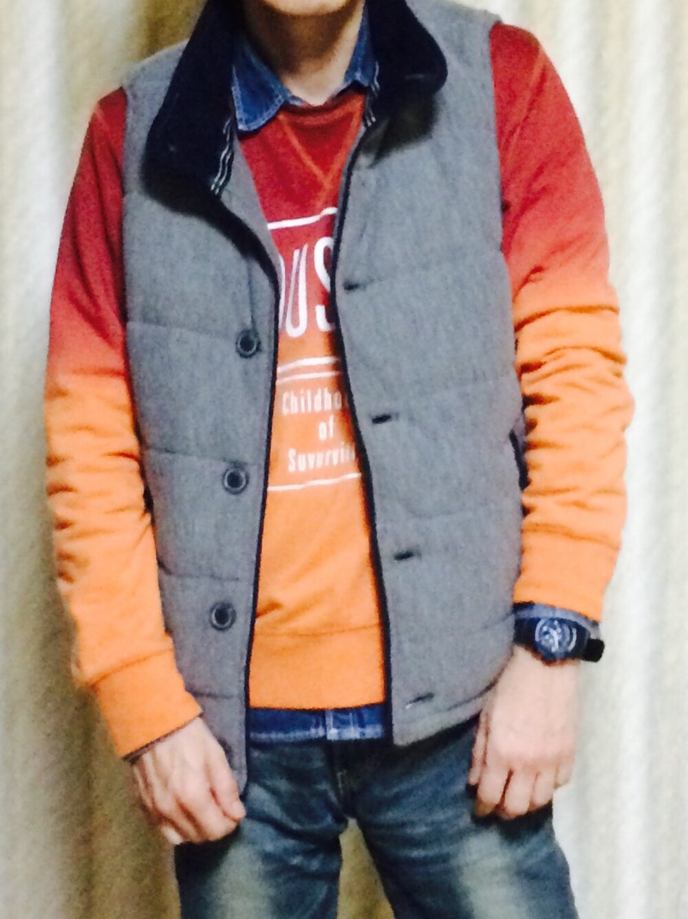 グレー系のダウンベスト、オレンジ系のスウェット、ブルー系のシャツ/ブラウスを着用したメンズの冬コーディネートの1枚目の写真