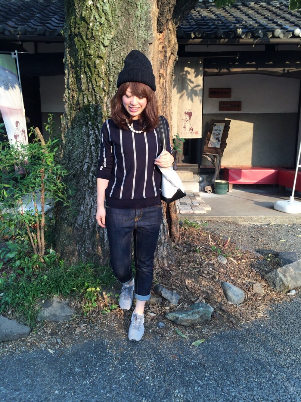 ホワイト系のトートバッグ、グレー系のスニーカー、ブルー系のデニムパンツを着用したレディースの秋コーディネートの1枚目の写真