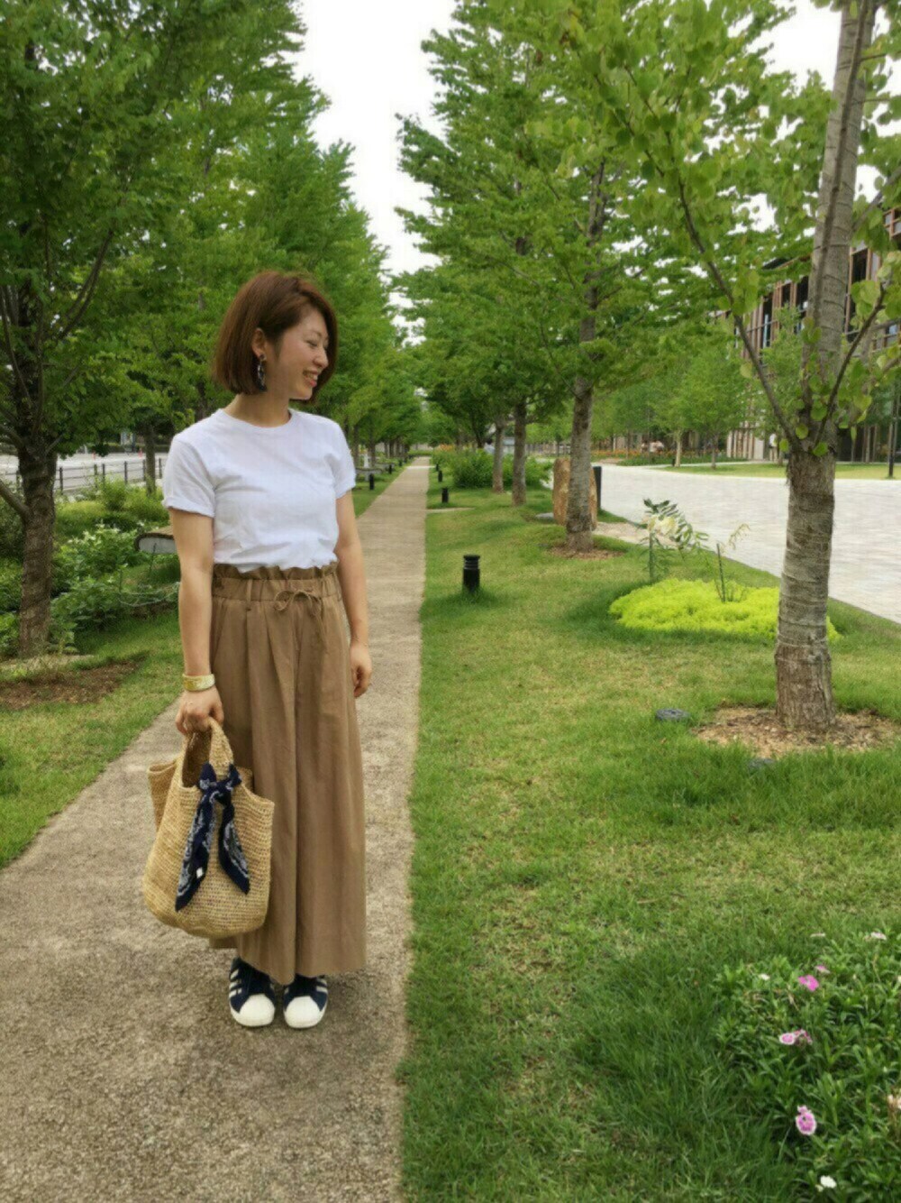 ホワイト系のTシャツ/カットソー、ベージュ系のかごバッグ、ベージュ系のその他パンツを着用したレディースの夏コーディネートの1枚目の写真
