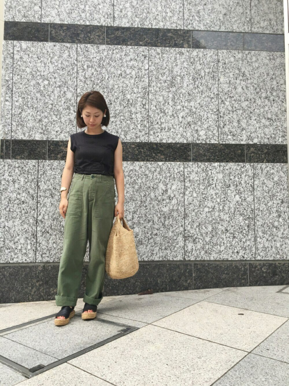 ブラック系のTシャツ/カットソー、グリーン系のカーゴパンツ、ベージュ系のかごバッグを着用したレディースの夏コーディネートの1枚目の写真