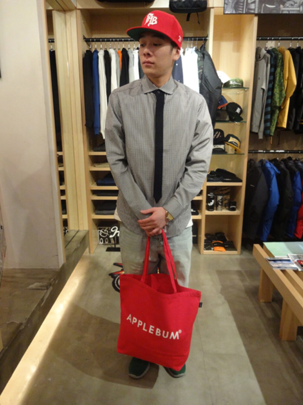ブラック系のシャツ/ブラウス、レッド系のトートバッグ、レッド系のキャップを着用したメンズの春コーディネートの1枚目の写真