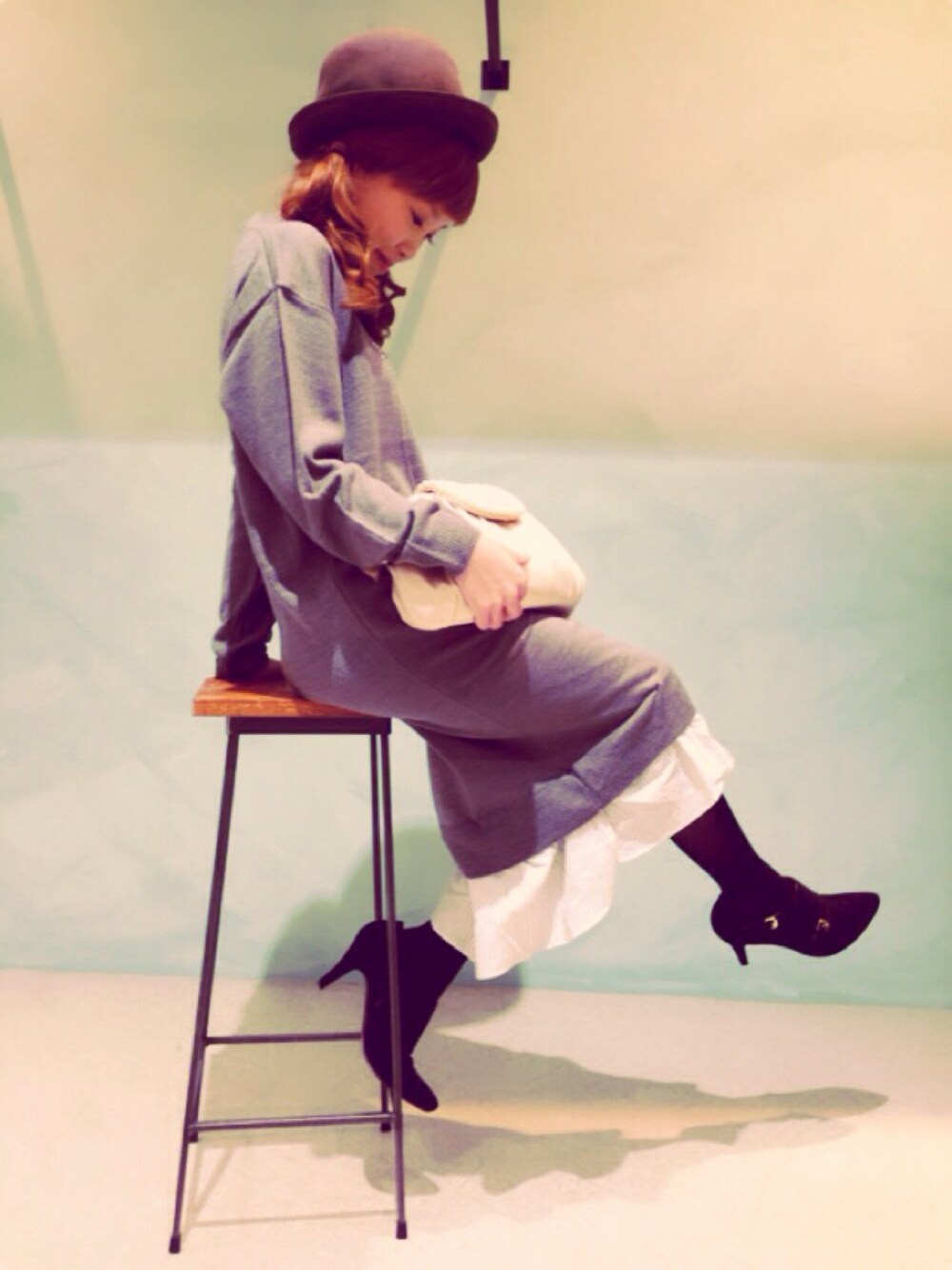 ブラック系のブーティ、ベージュ系のクラッチバッグ、グレー系のワンピースを着用したレディースの秋コーディネートの1枚目の写真