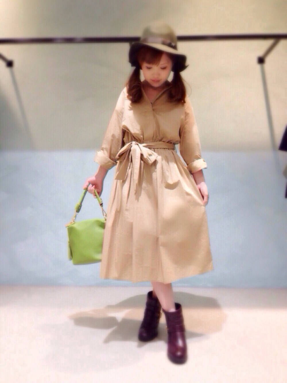 グリーン系のトートバッグ、ベージュ系のワンピース、グリーン系のハットを着用したレディースの冬コーディネートの1枚目の写真