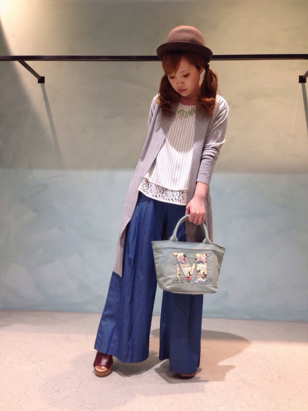 グレー系のカーディガン/ボレロ、ブラウン系のサンダル、ブルー系のデニムパンツを着用したレディースの春コーディネートの1枚目の写真