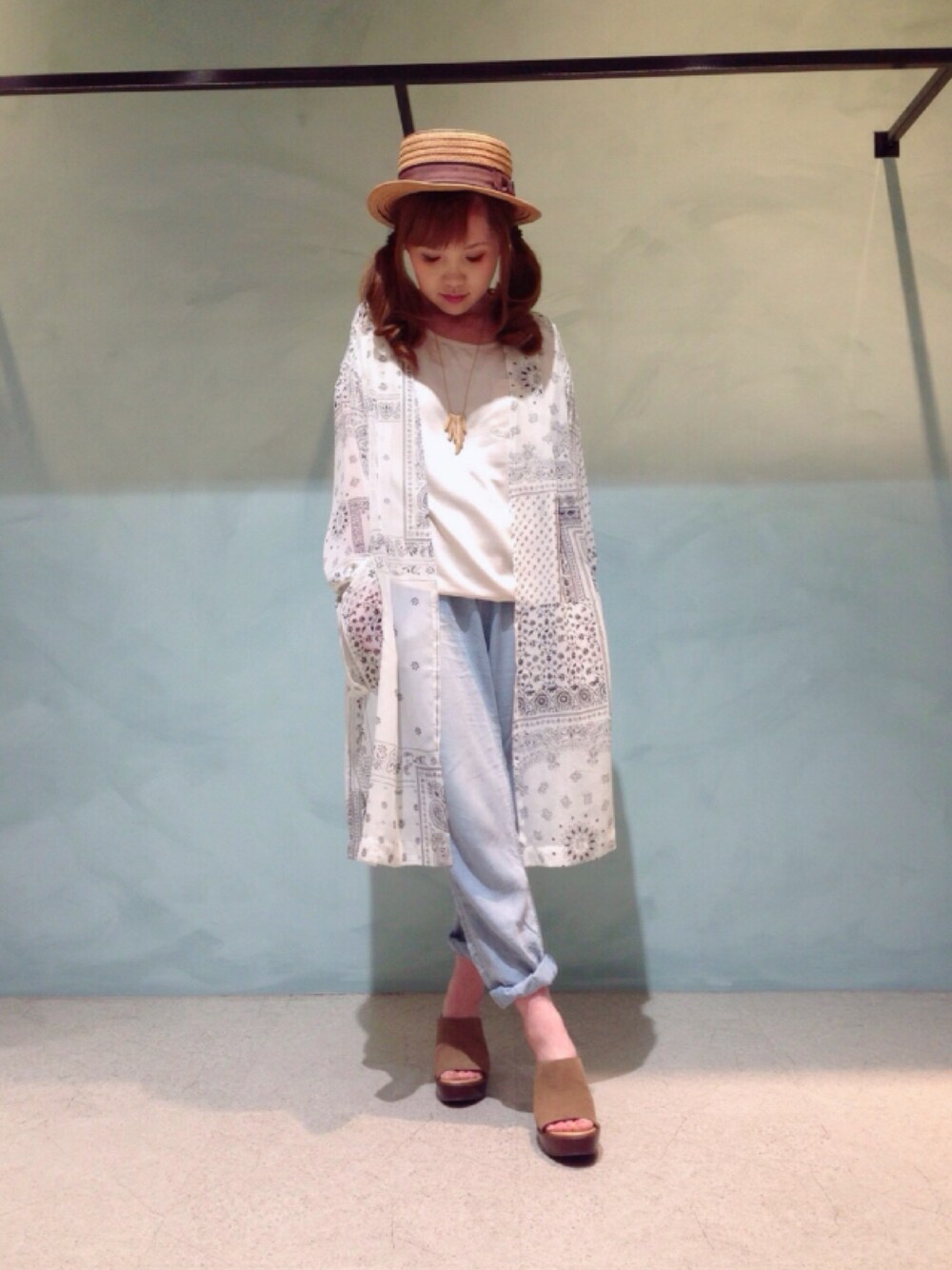 ホワイト系のカーディガン/ボレロ、ブルー系のデニムパンツ、ベージュ系のサンダルを着用したレディースの春コーディネートの1枚目の写真