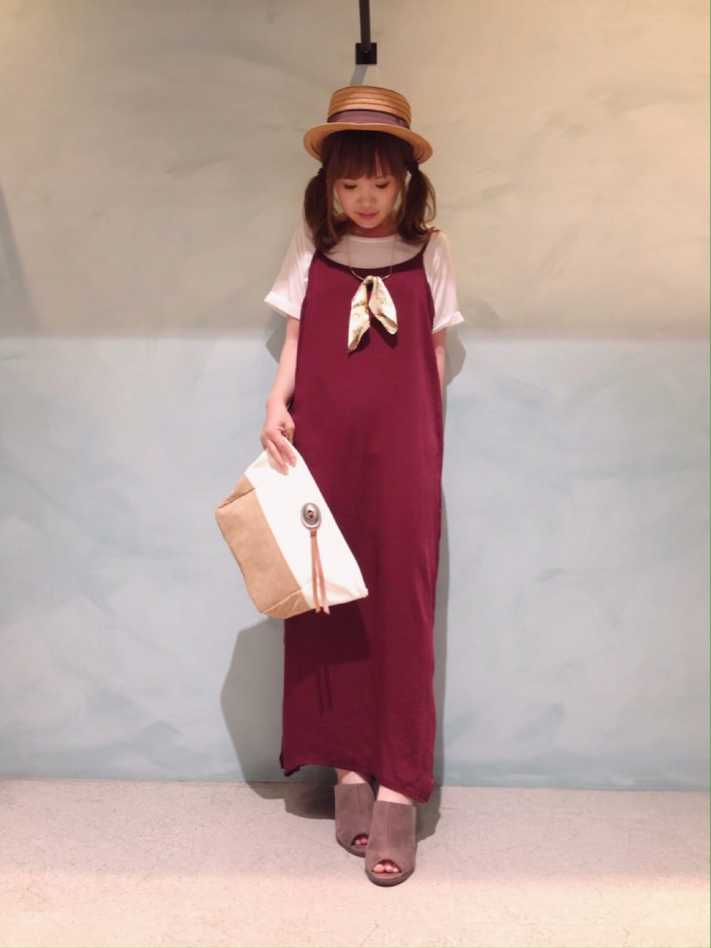 ベージュ系のサンダル、ベージュ系のクラッチバッグ、レッド系のワンピースを着用したレディースの夏コーディネートの1枚目の写真