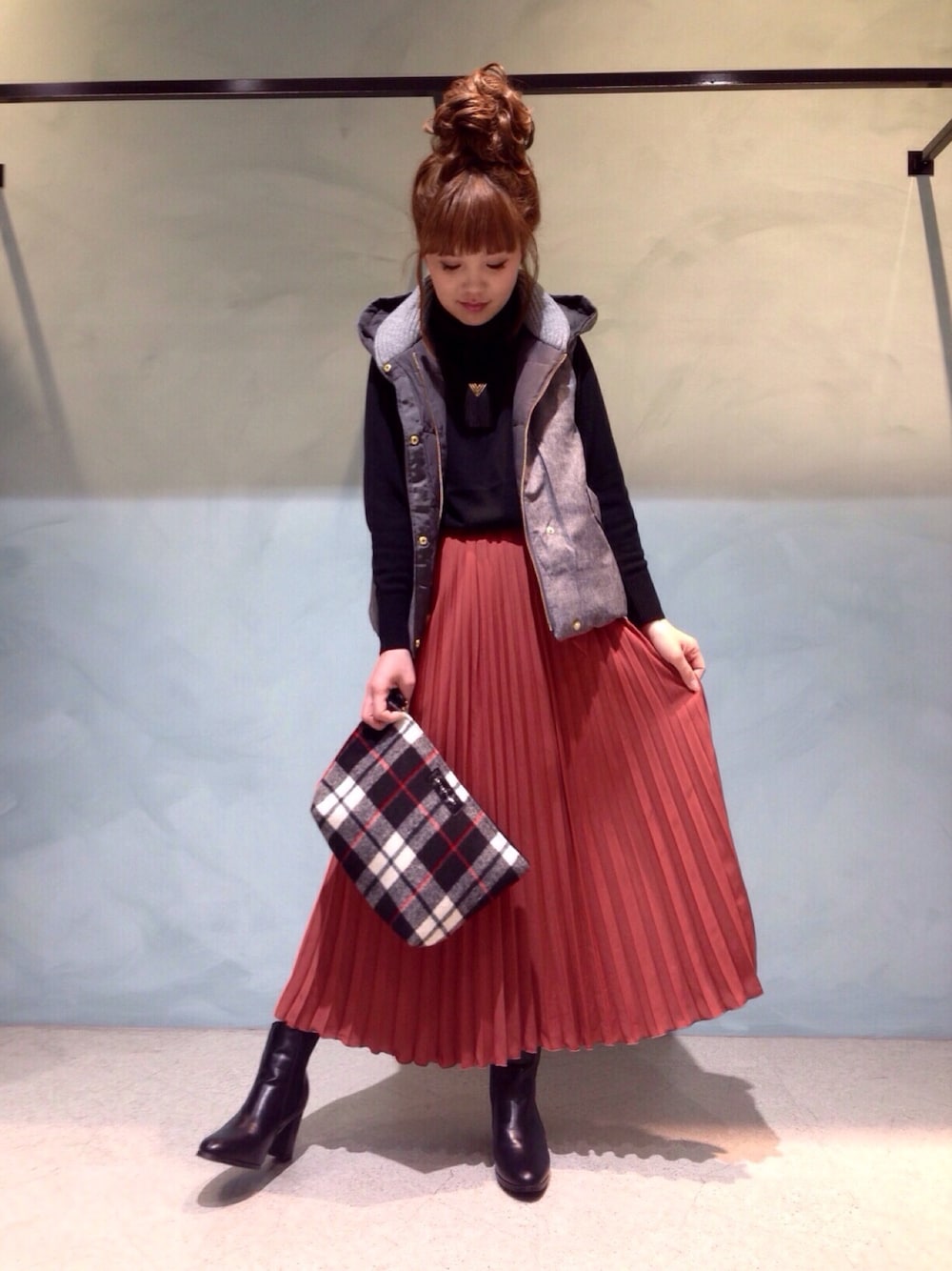 ブラック系のブーツ、グレー系のダウンベスト、ブラック系のニット/セーターを着用したレディースの秋コーディネートの1枚目の写真