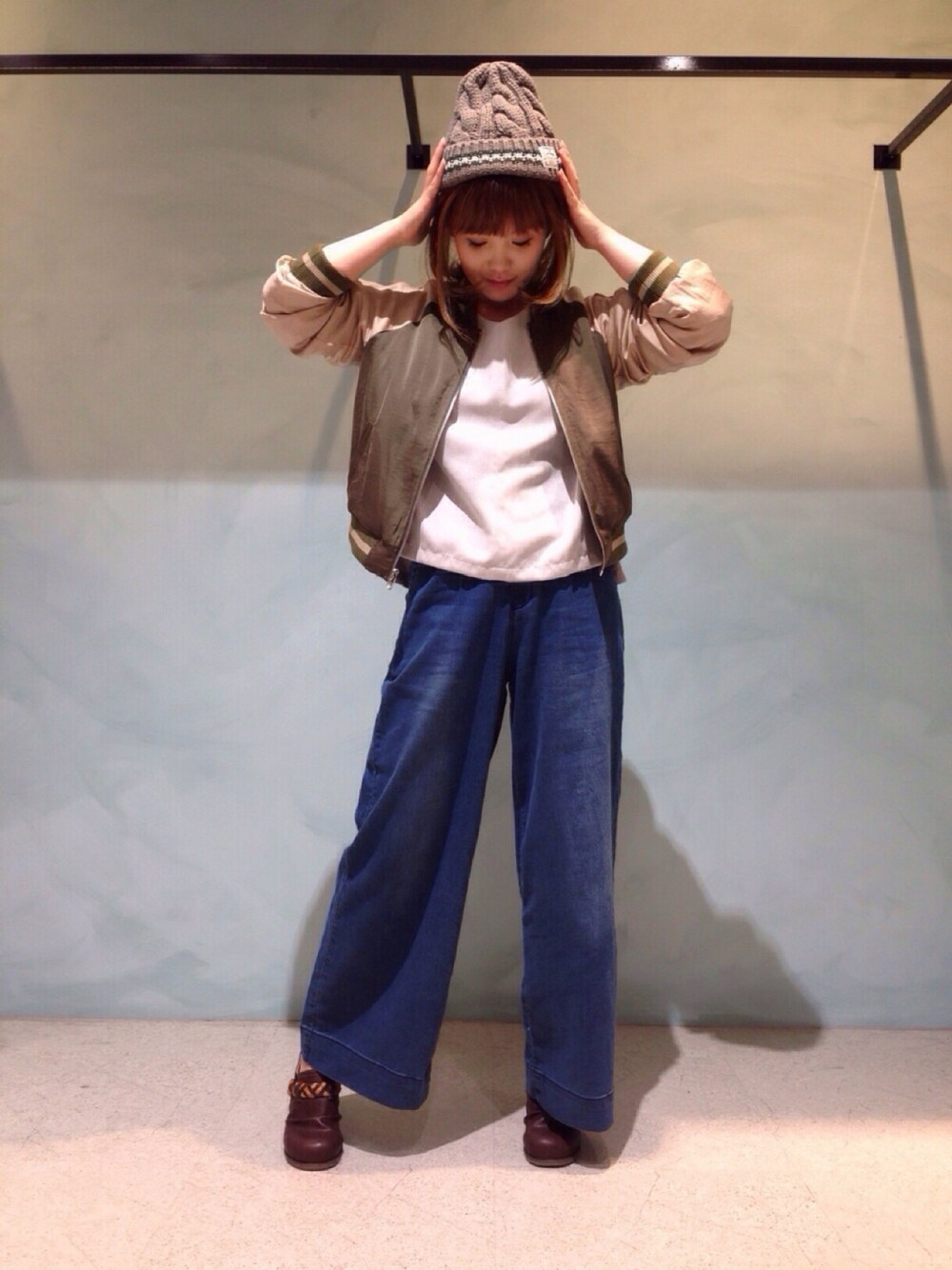 グリーン系のMA-1、グレー系のシャツ/ブラウス、ブルー系のデニムパンツを着用したレディースの秋コーディネートの1枚目の写真