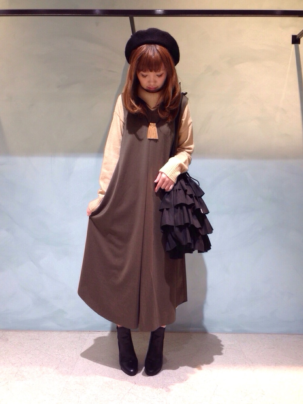 ベージュ系のワンピース、ブラック系のトートバッグ、ブラック系のブーツを着用したレディースの冬コーディネートの1枚目の写真