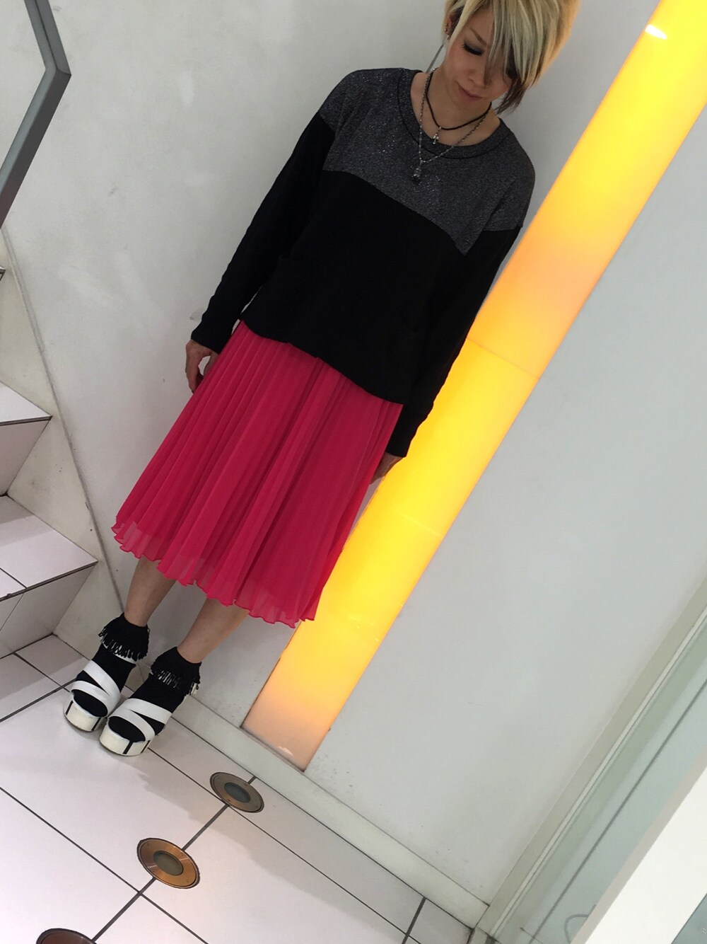 ブラック系のニット/セーター、ピンク系のスカート、ホワイト系のサンダルを着用したレディースの春コーディネートの1枚目の写真