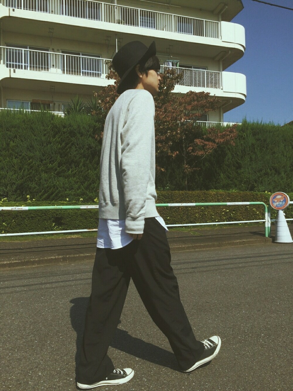 グレー系のスウェット、ブラック系のパンツ、ブラック系のスニーカーを着用したメンズの秋コーディネートの1枚目の写真