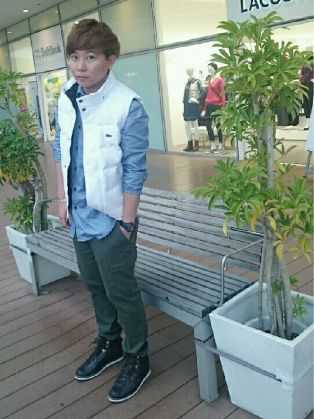 グリーン系のカーゴパンツ、ブラウン系のスニーカー、ホワイト系のダウンベストを着用したメンズの秋コーディネートの1枚目の写真