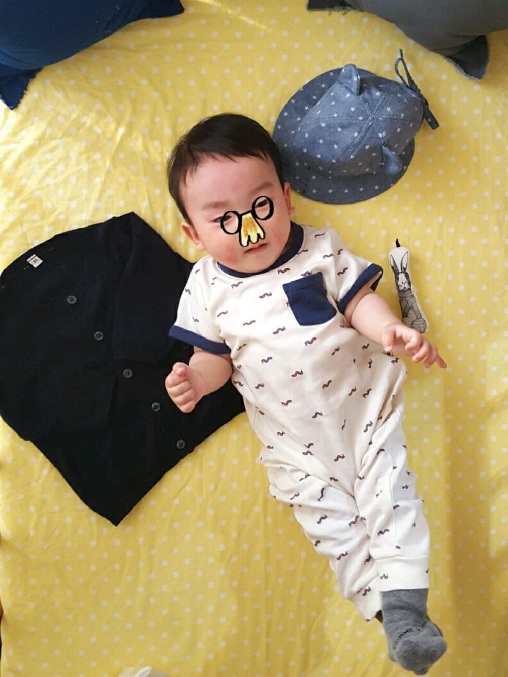 ブルー系のカーディガン/ボレロ、ブルー系のキャップ、ホワイト系のロンパースを着用したキッズの春コーディネートの1枚目の写真