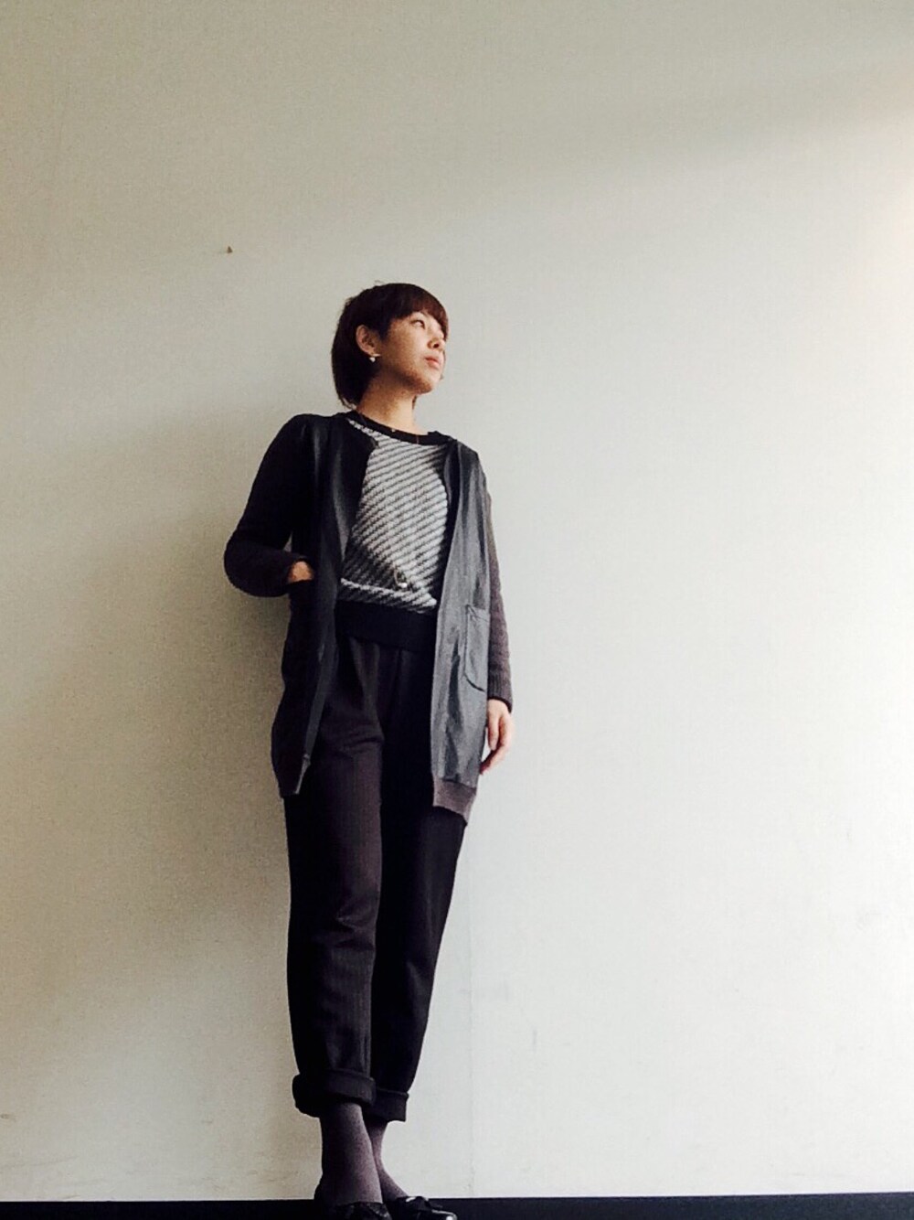 ブラック系のノーカラージャケットを着用したレディースの冬コーディネートの1枚目の写真