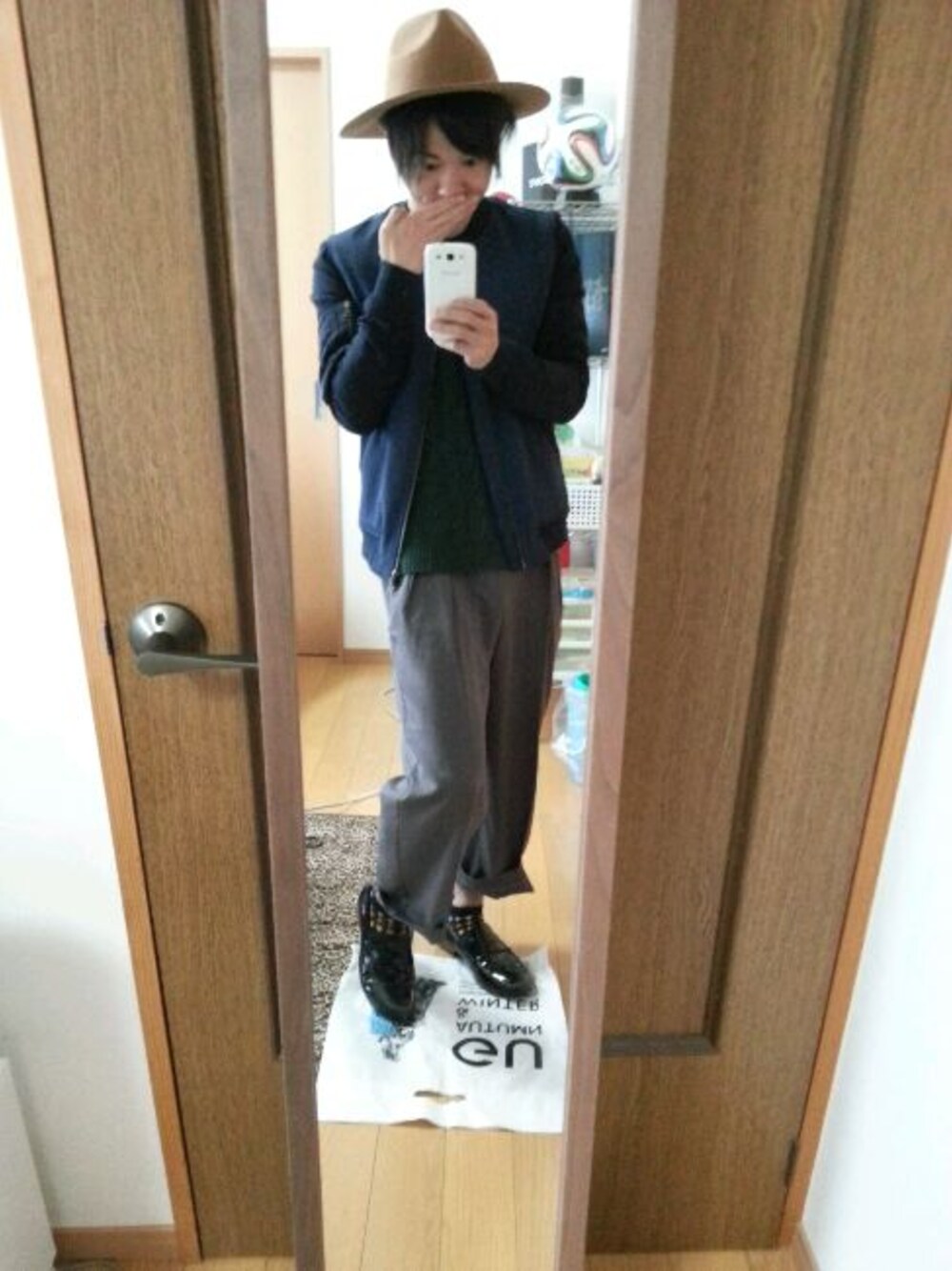 ブルー系のブルゾン、グリーン系のニット/セーター、グレー系のスラックスを着用したメンズの冬コーディネートの1枚目の写真