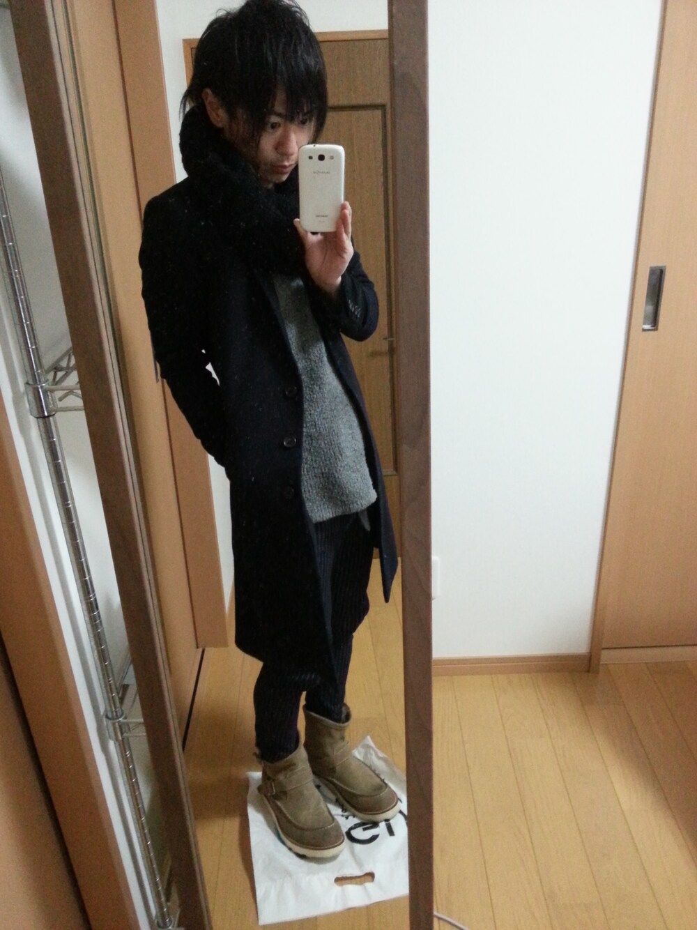 ブルー系のチェスターコート、グレー系のニット/セーター、ブルー系のその他パンツを着用したメンズの冬コーディネートの1枚目の写真