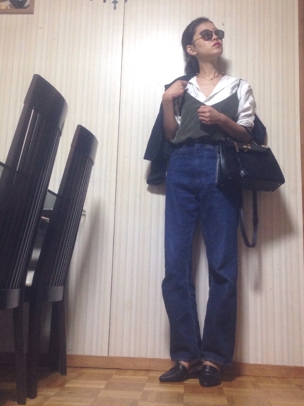 ブラック系のライダースジャケット、ホワイト系のシャツ/ブラウス、グリーン系のキャミソールを着用したレディースの秋コーディネートの1枚目の写真