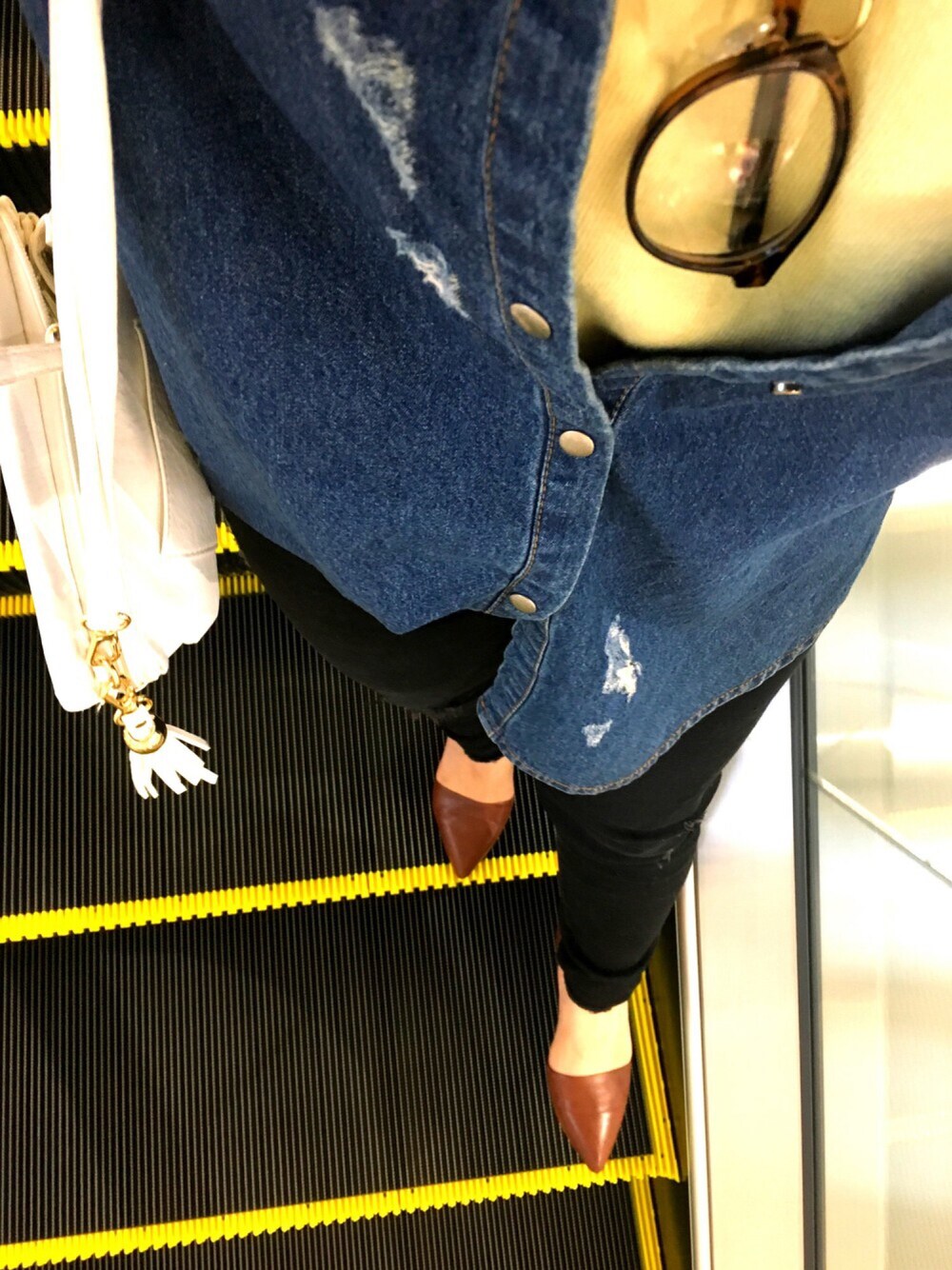 ブルー系のシャツ/ブラウス、イエロー系のニット/セーター、ブラック系のデニムパンツを着用したレディースの冬コーディネートの1枚目の写真