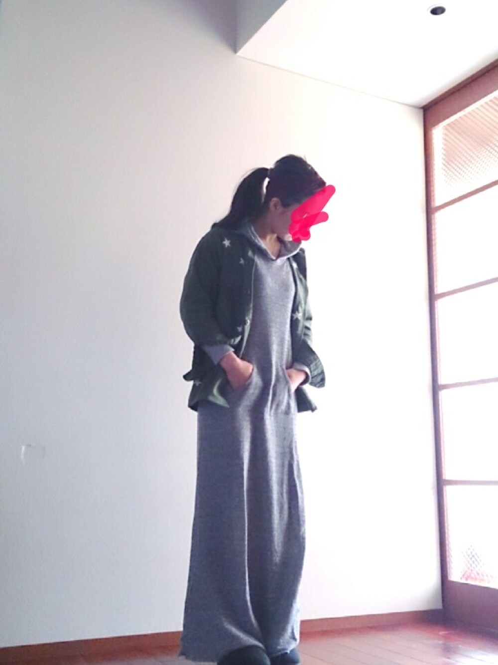 グリーン系のミリタリージャケット、ブラック系のブーツ、グレー系のワンピースを着用したレディースの春コーディネートの1枚目の写真