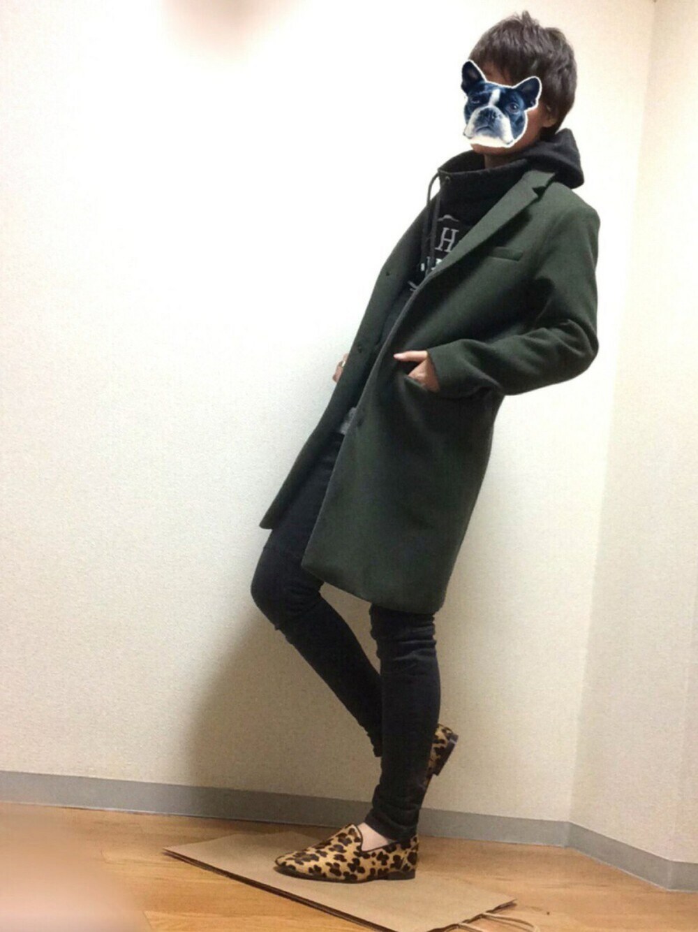 グリーン系のチェスターコート、ブラック系のその他パンツ、ブラック系のパーカーを着用したメンズの春コーディネートの1枚目の写真