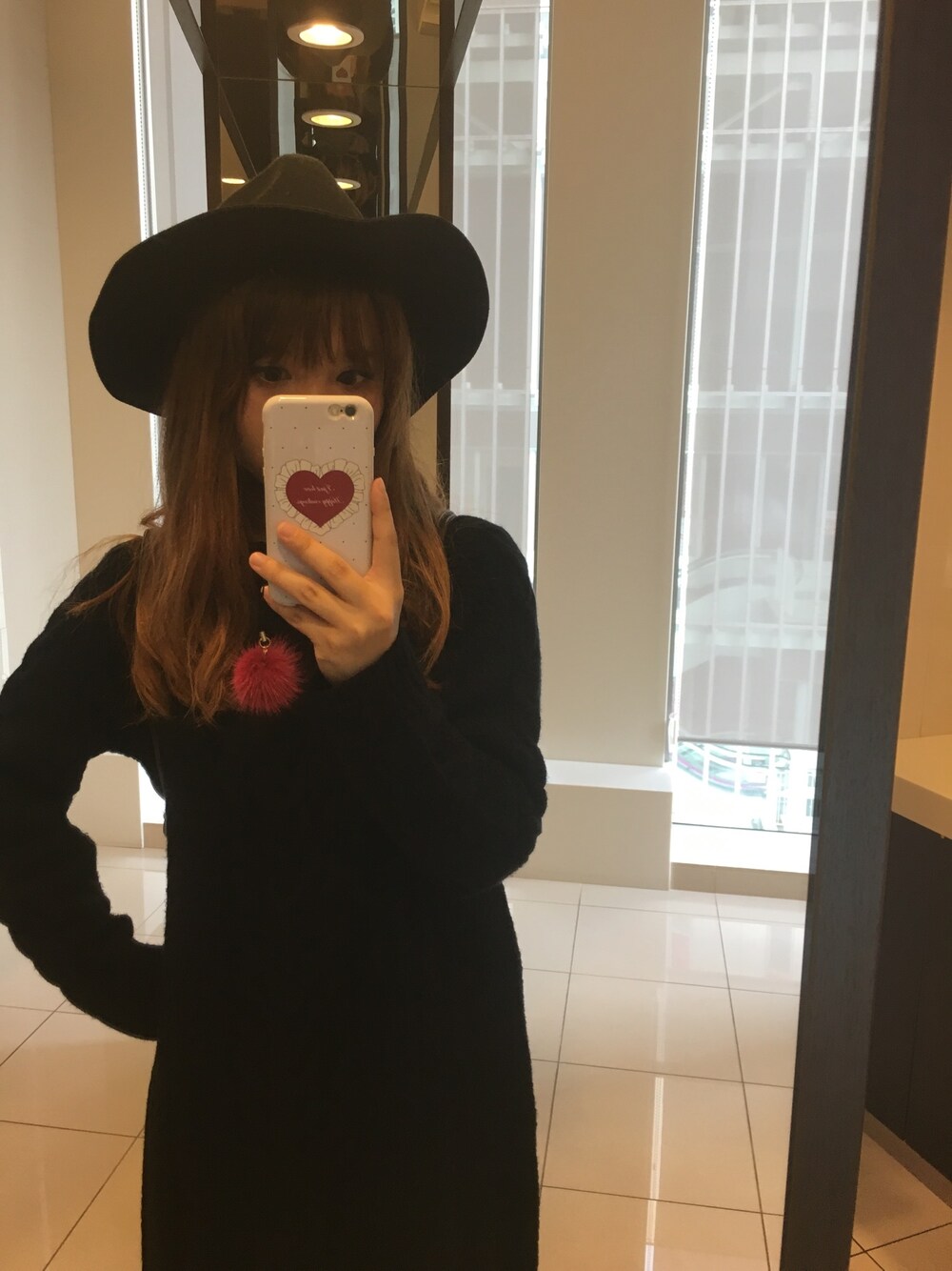 ブラック系のワンピース、ホワイト系のスマホケース/カバー、ブラック系のハットを着用したレディースの秋コーディネートの1枚目の写真