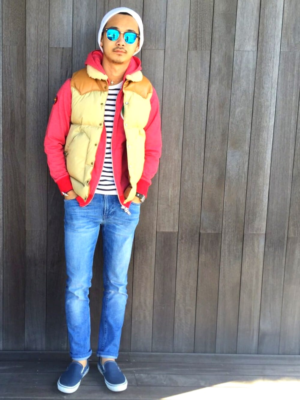 レッド系のパーカー、ホワイト系のTシャツ/カットソー、ブラウン系のダウンベストを着用したメンズの冬コーディネートの1枚目の写真