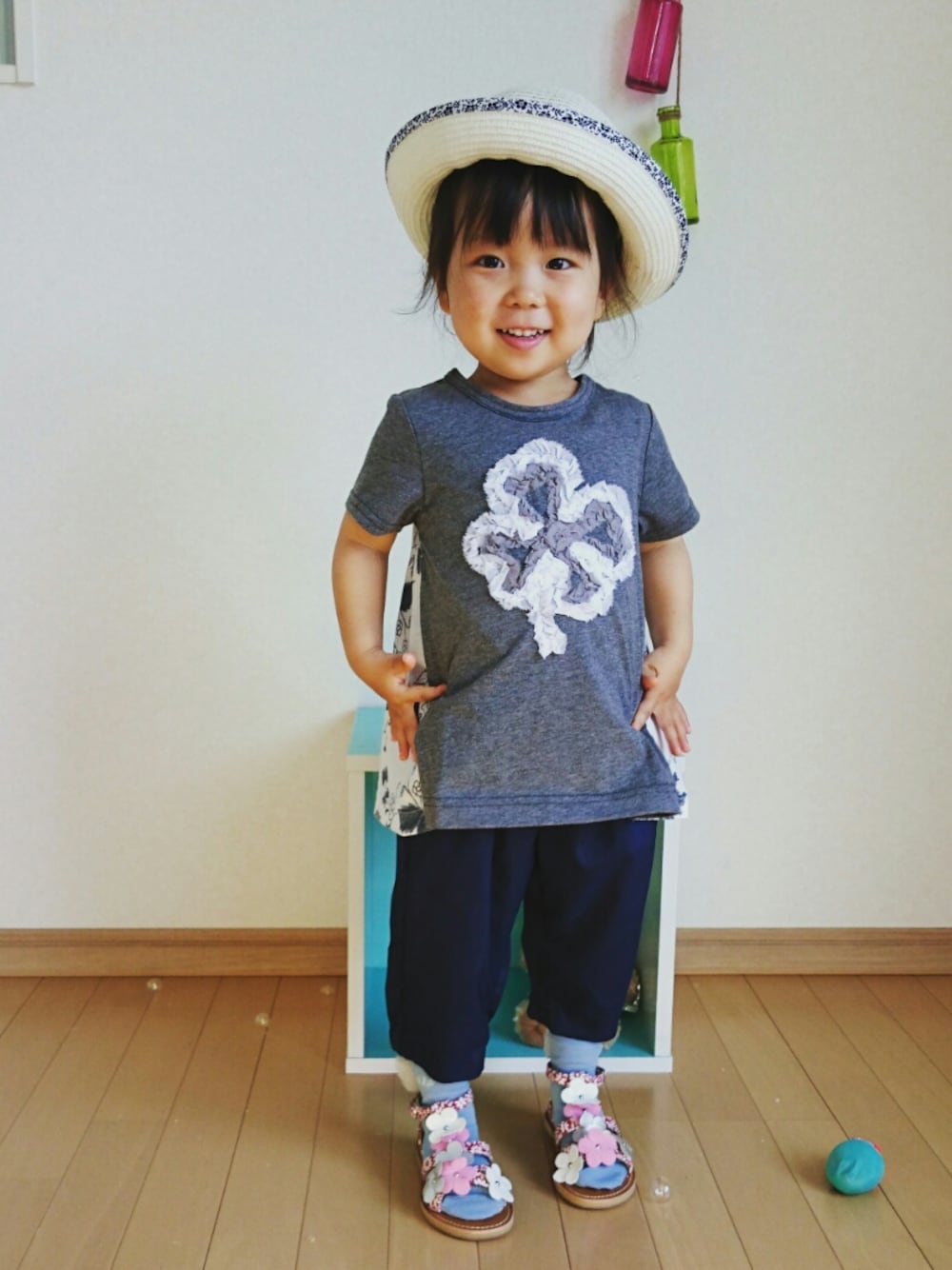 レッド系のサンダル、ブルー系のその他パンツ、グレー系のチュニックを着用したキッズの春コーディネートの1枚目の写真