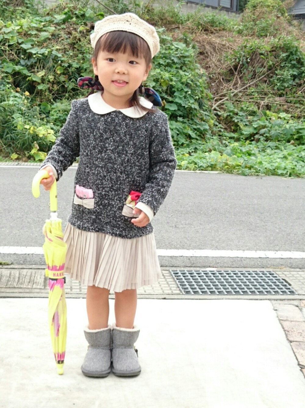 グレー系のワンピース/ドレス、グレー系のブーツ、イエロー系の長傘を着用したキッズの秋コーディネートの1枚目の写真