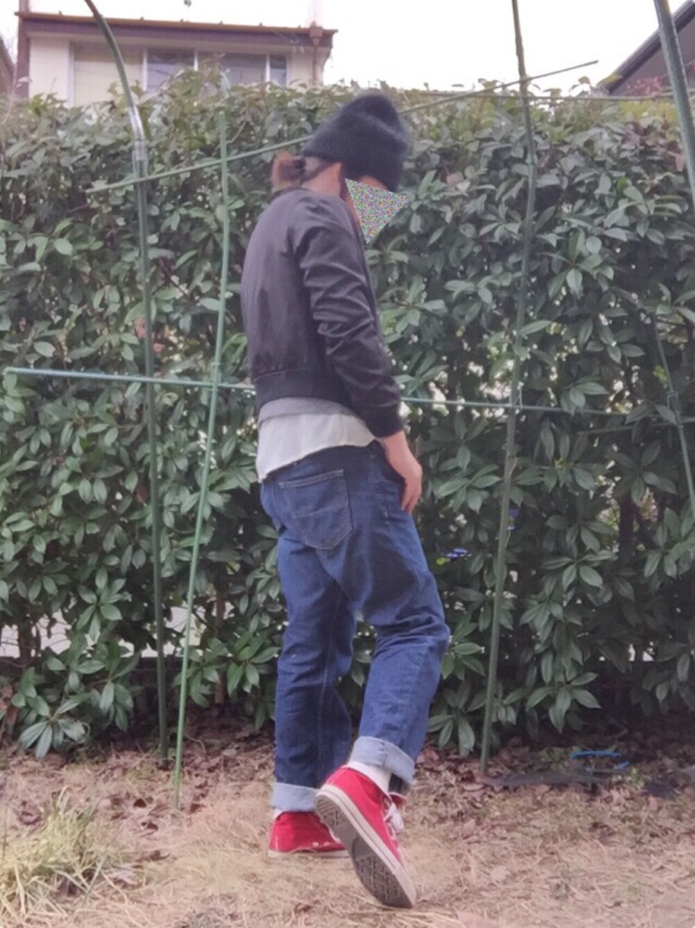 グレー系のスウェット、ブルー系のデニムパンツ、レッド系のスニーカーを着用したレディースの冬コーディネートの1枚目の写真