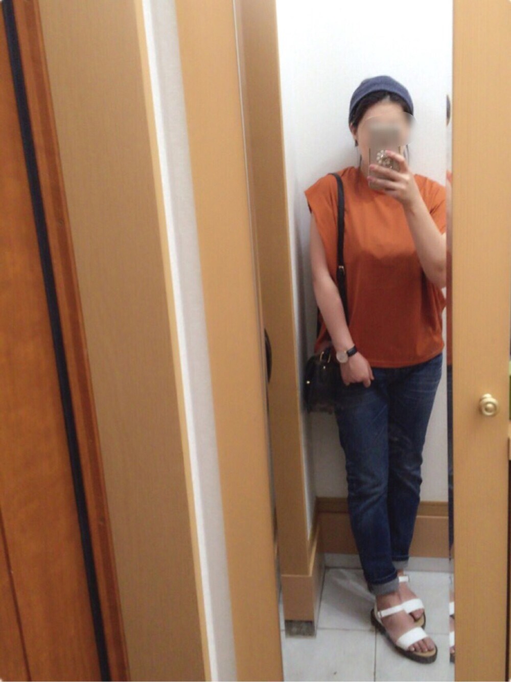 オレンジ系のTシャツ/カットソー、ホワイト系のサンダル、ブラック系のショルダーバッグを着用したレディースの夏コーディネートの1枚目の写真