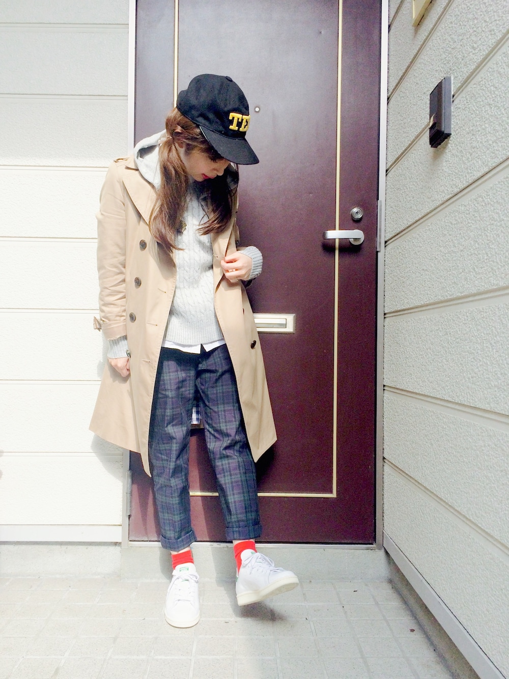 ホワイト系のスニーカー、ベージュ系のトレンチコート、グレー系のパーカーを着用したレディースの秋コーディネートの1枚目の写真