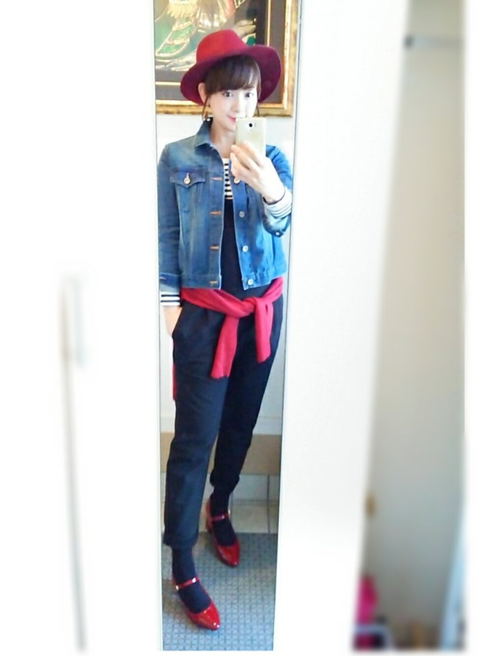 ブラック系のサロペット/オーバーオール、ブルー系のデニムジャケット、レッド系のニット/セーターを着用したレディースの冬コーディネートの1枚目の写真