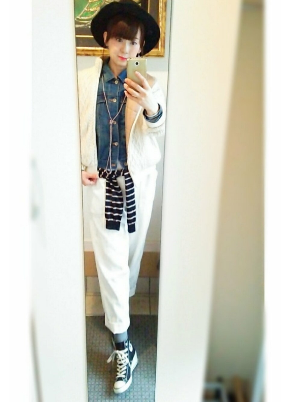 ブルー系のデニムジャケット、ブラック系のスニーカー、ホワイト系のその他パンツを着用したレディースの冬コーディネートの1枚目の写真