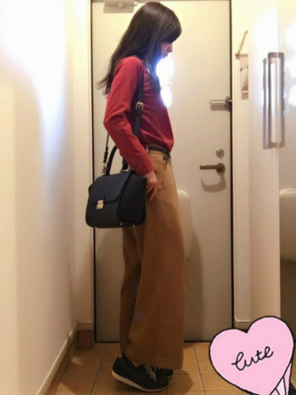 ブラウン系のパンツ、ブラック系のスニーカー、ブラック系のバッグを着用したレディースの秋コーディネートの1枚目の写真