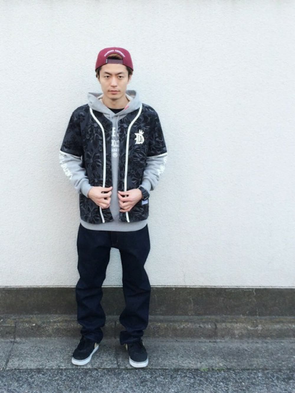 グレー系のパーカー、その他のデニムパンツ、レッド系のキャップを着用したメンズの冬コーディネートの1枚目の写真