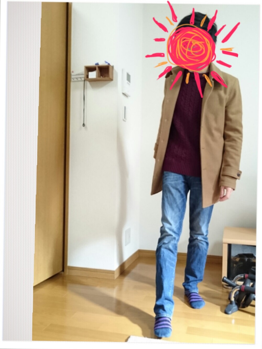 ブルー系のデニムパンツ、レッド系のニット/セーター、ベージュ系のステンカラーコートを着用したメンズの冬コーディネートの1枚目の写真