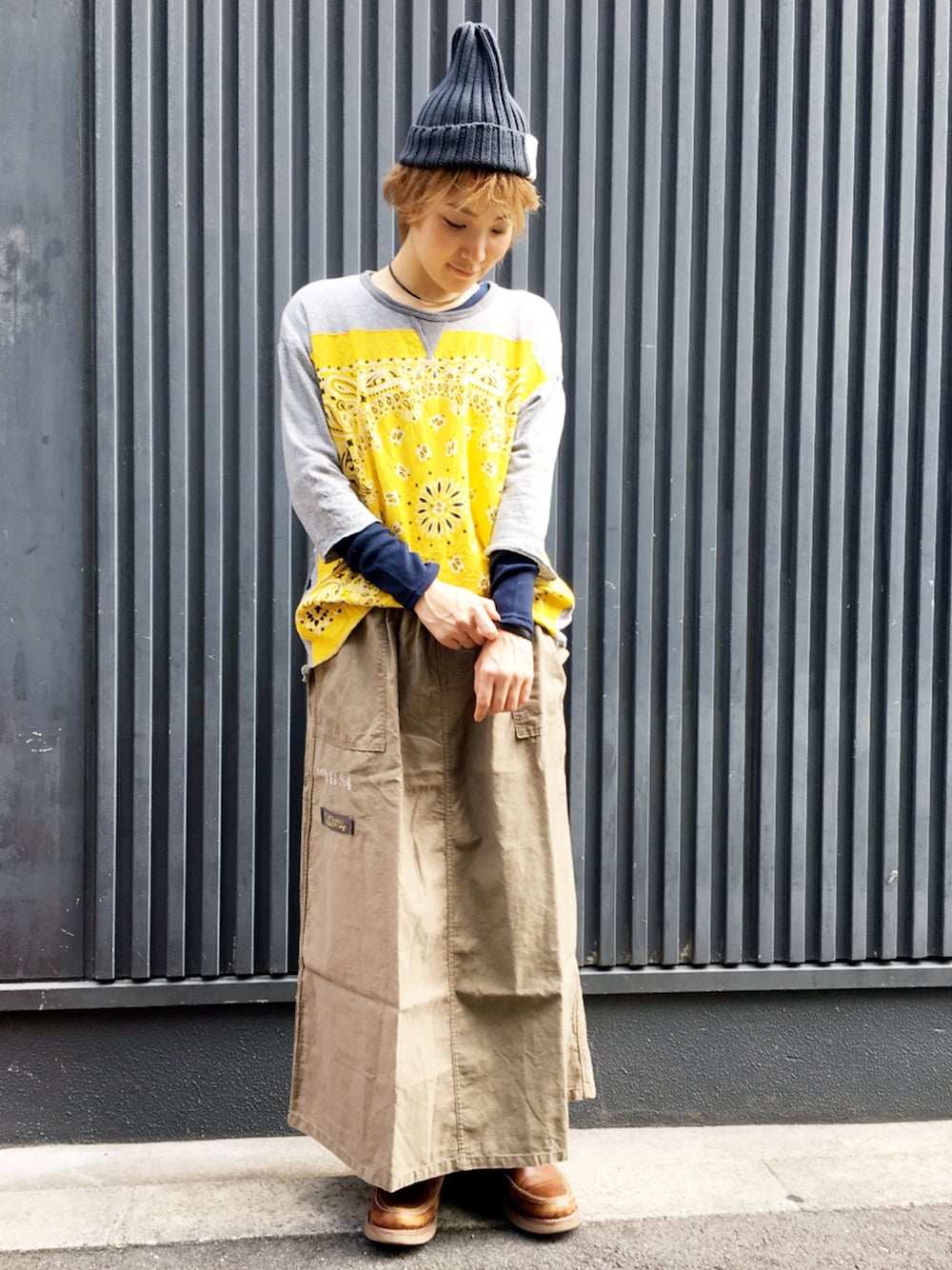 ベージュ系のスカート、イエロー系のスウェット、ブラウン系のブーツを着用したレディースの秋コーディネートの1枚目の写真