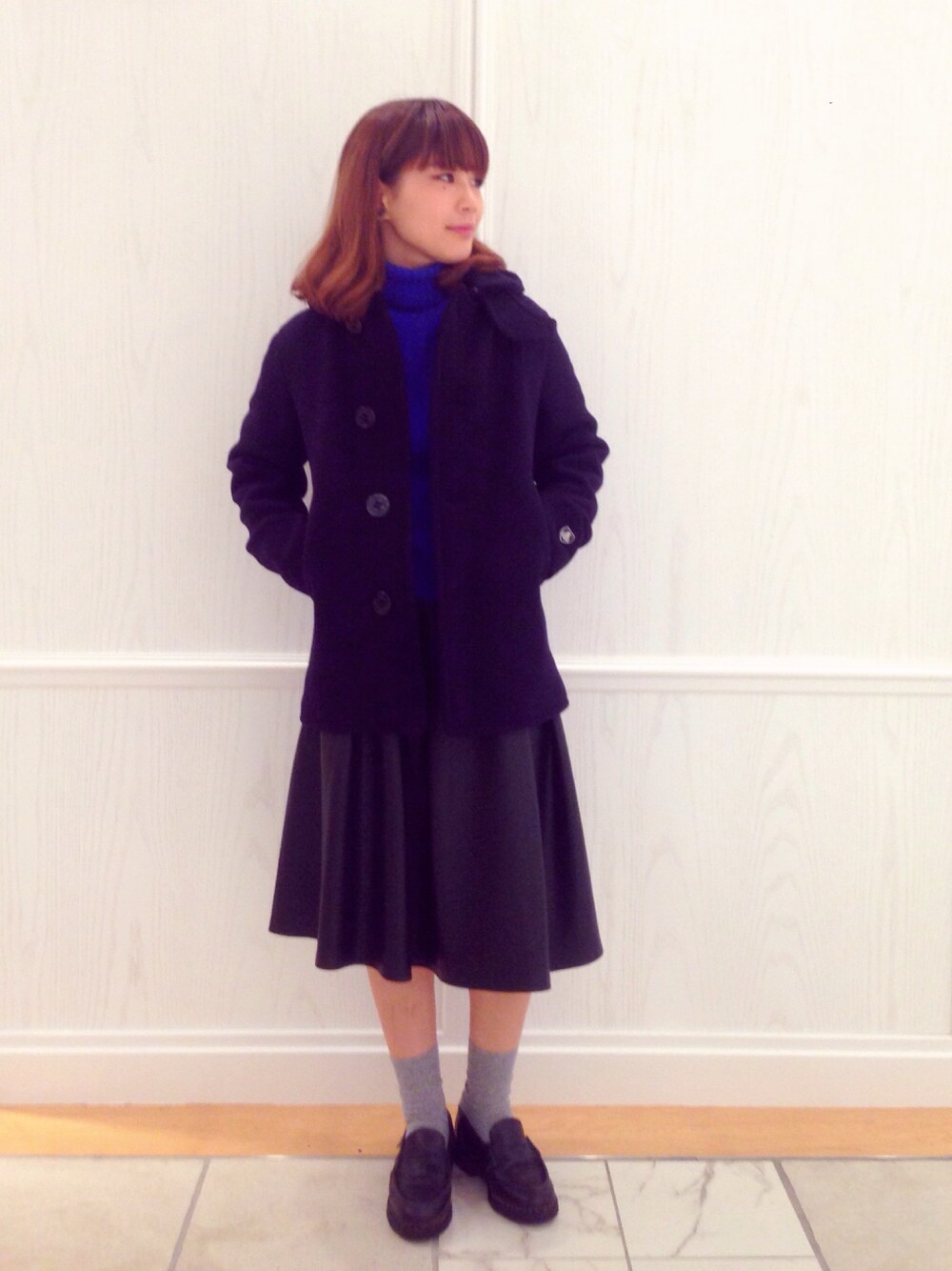 ブルー系のピーコート、ブラック系のスカート、ブラック系のその他シューズを着用したレディースの秋コーディネートの1枚目の写真