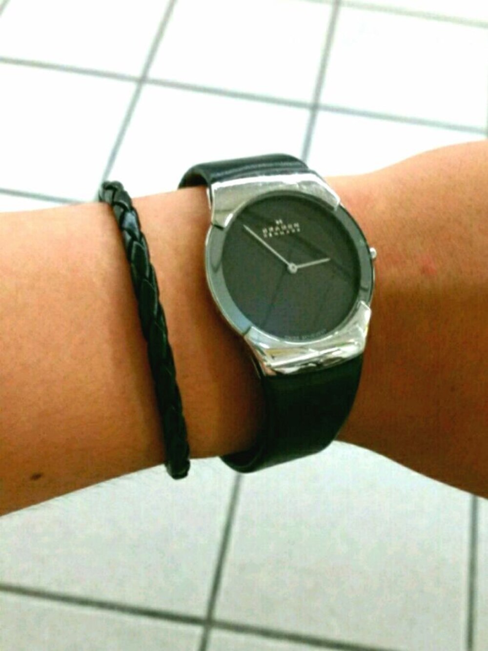 ブラック系のアナログ腕時計、ブラック系のブレスレットを着用したメンズの夏コーディネートの1枚目の写真