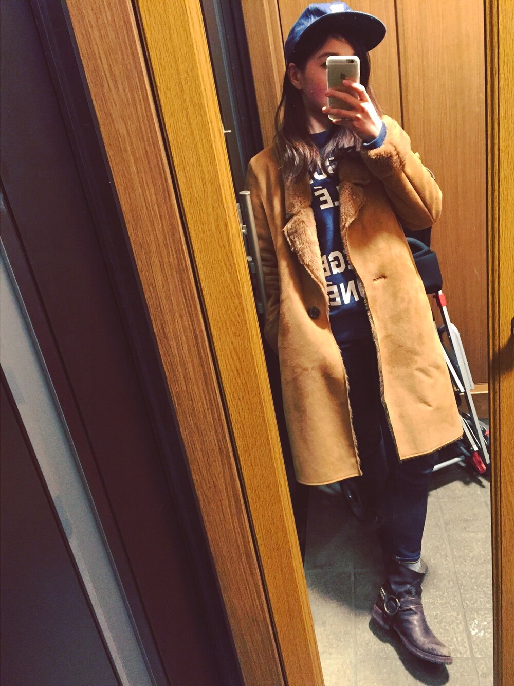 ブラウン系のムートンコート、ブルー系のスウェット、ブルー系のデニムパンツを着用したレディースの冬コーディネートの1枚目の写真