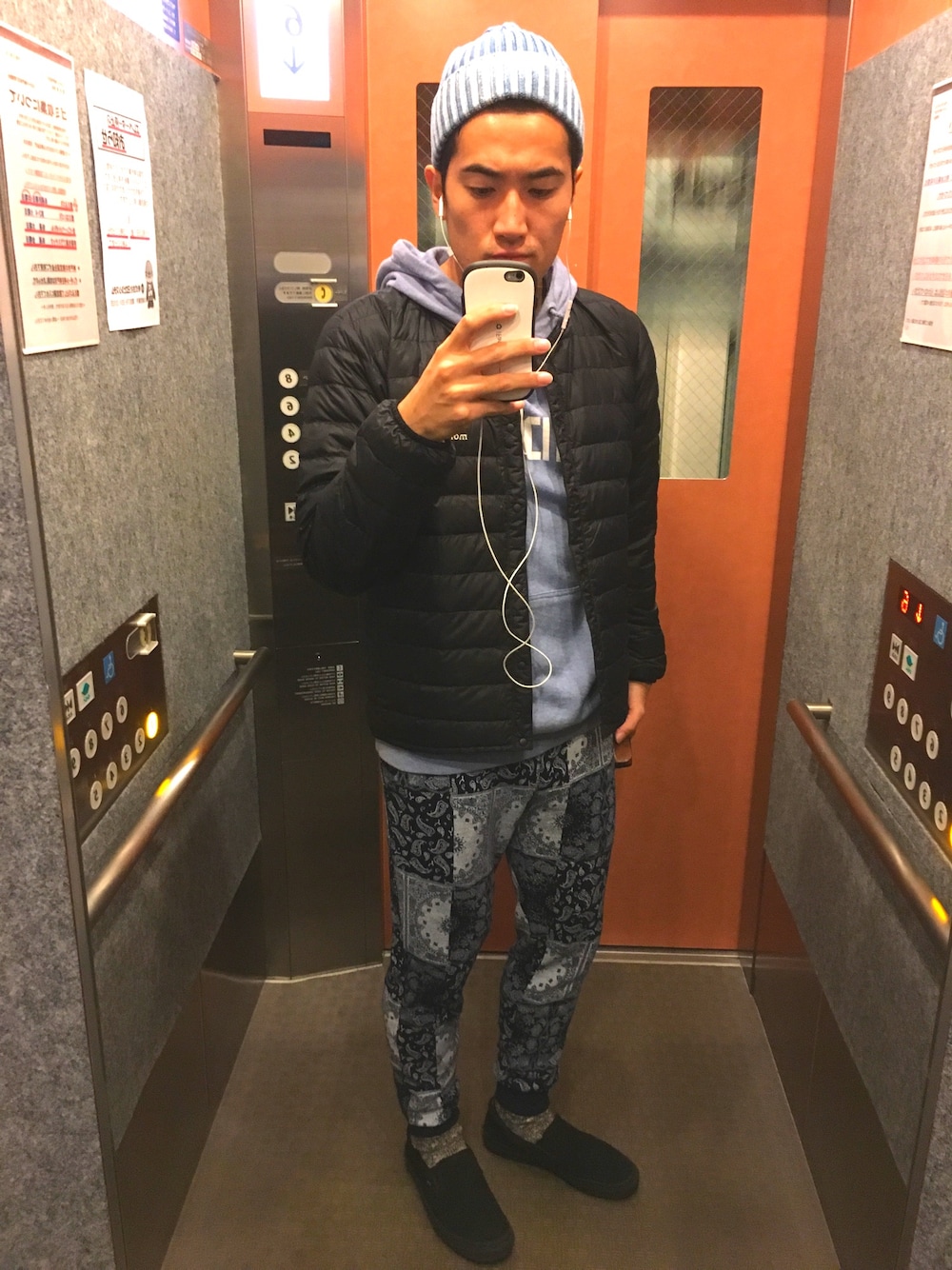 ブラック系のダウンジャケット/コート、ブルー系のその他パンツ、ブラック系のスリッポンを着用したメンズの秋コーディネートの1枚目の写真