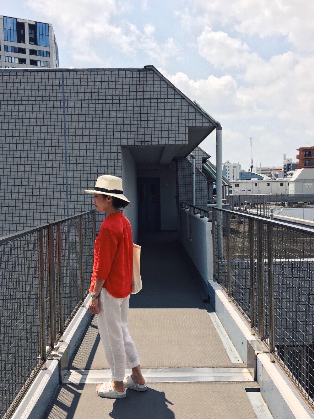 レッド系のシャツ/ブラウスを着用したレディースの夏コーディネートの1枚目の写真