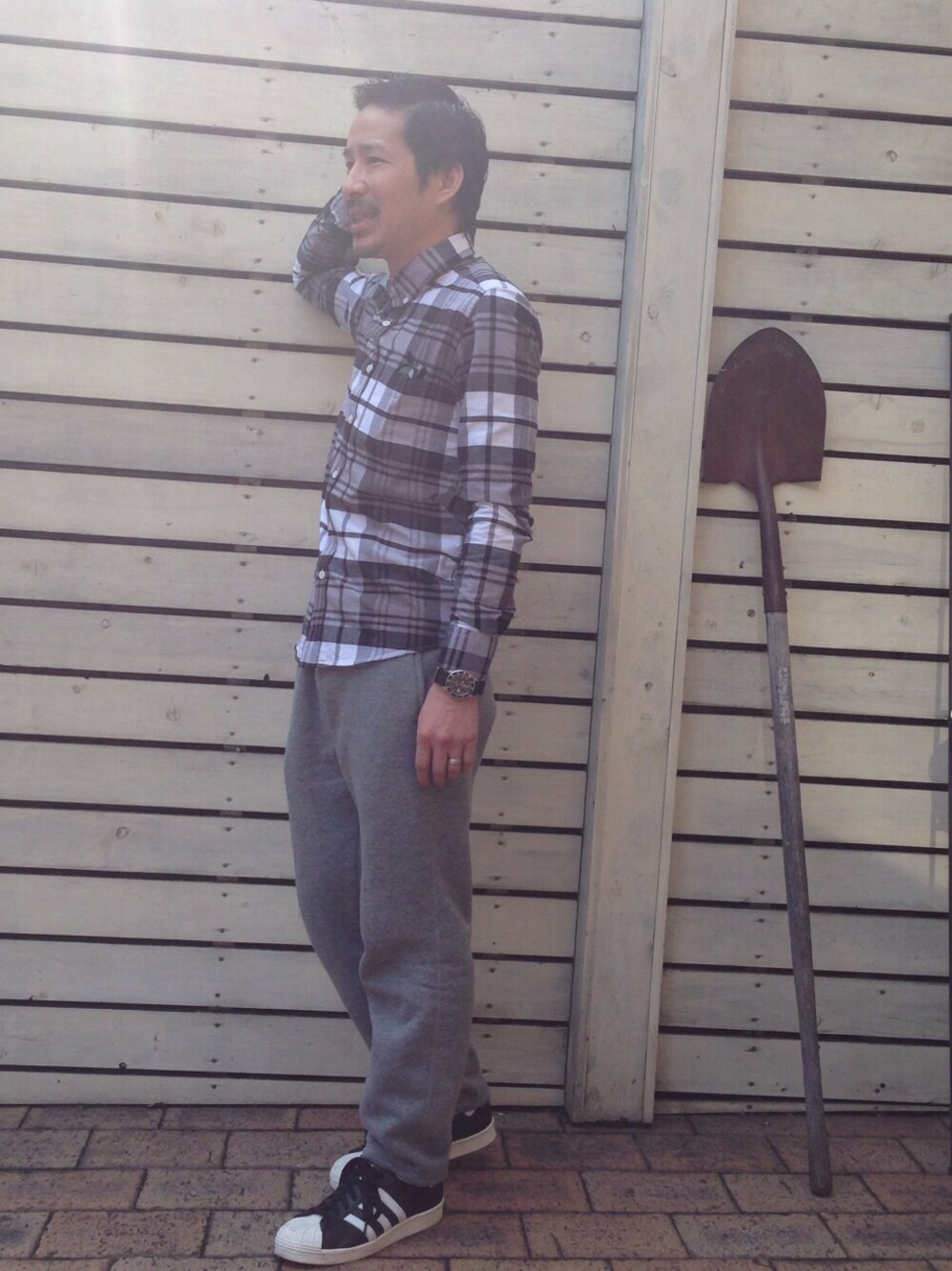 グレー系のシャツ/ブラウス、ブラック系のスニーカーを着用したメンズの冬コーディネートの1枚目の写真