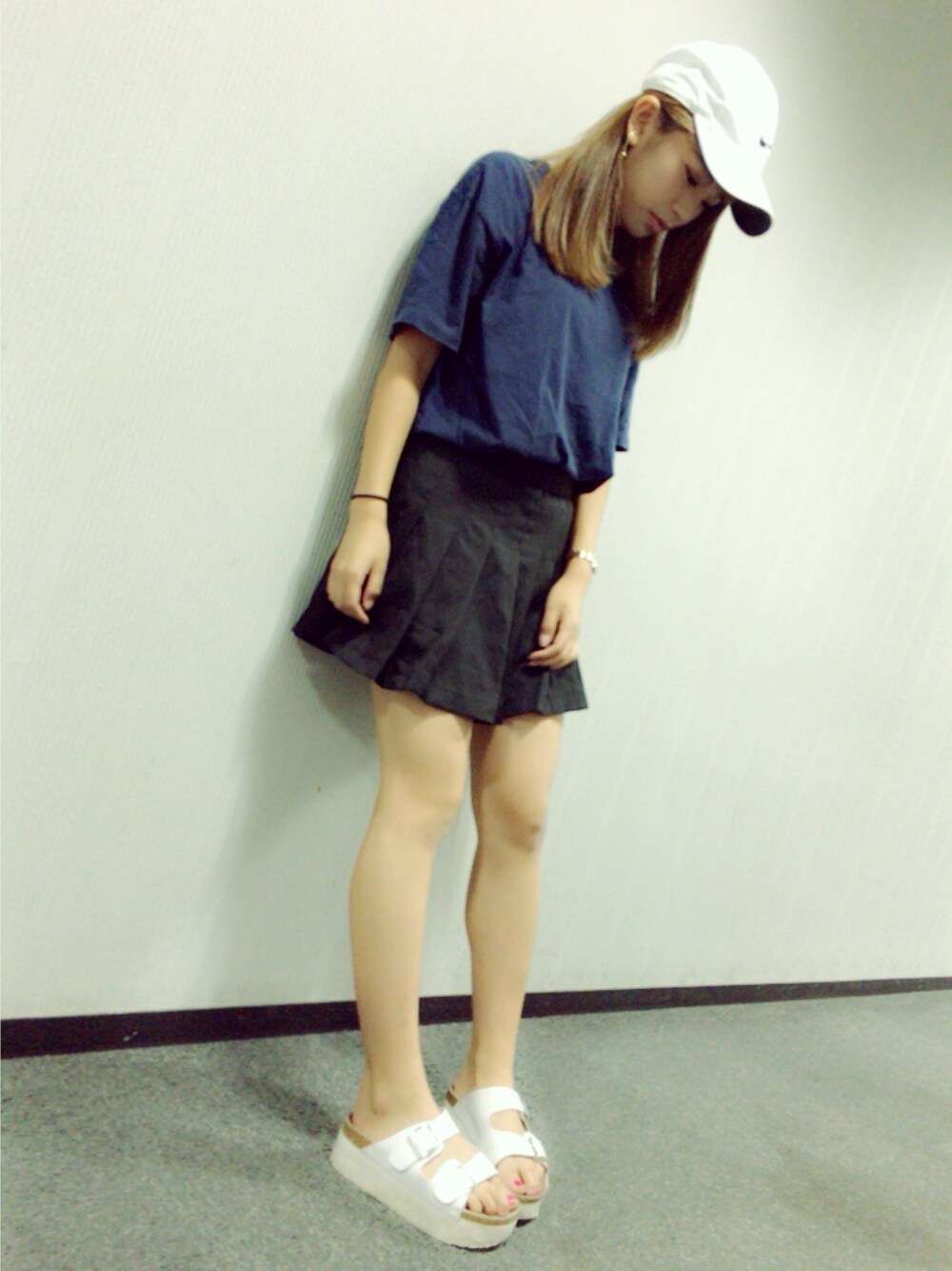 ブラック系のスカート、ブルー系のTシャツ/カットソー、ホワイト系のキャップを着用したレディースの夏コーディネートの1枚目の写真