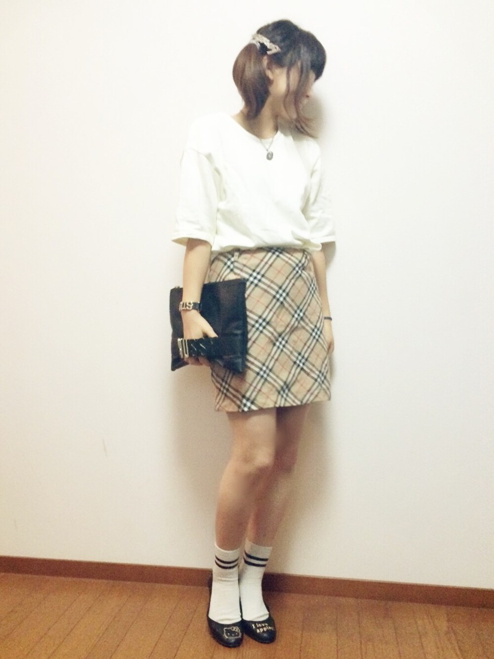 ベージュ系のスカート、ブラック系のパンプス、ブラック系のクラッチバッグを着用したレディースの秋コーディネートの1枚目の写真